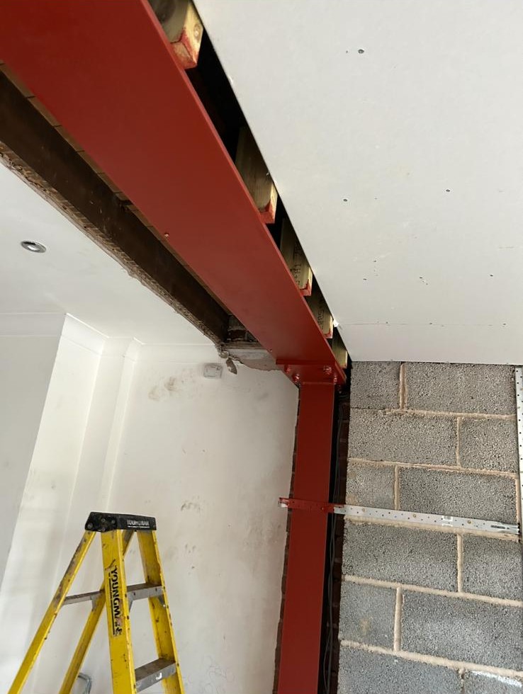 Red steel RSJ beam and supporting column installed to open up a wall