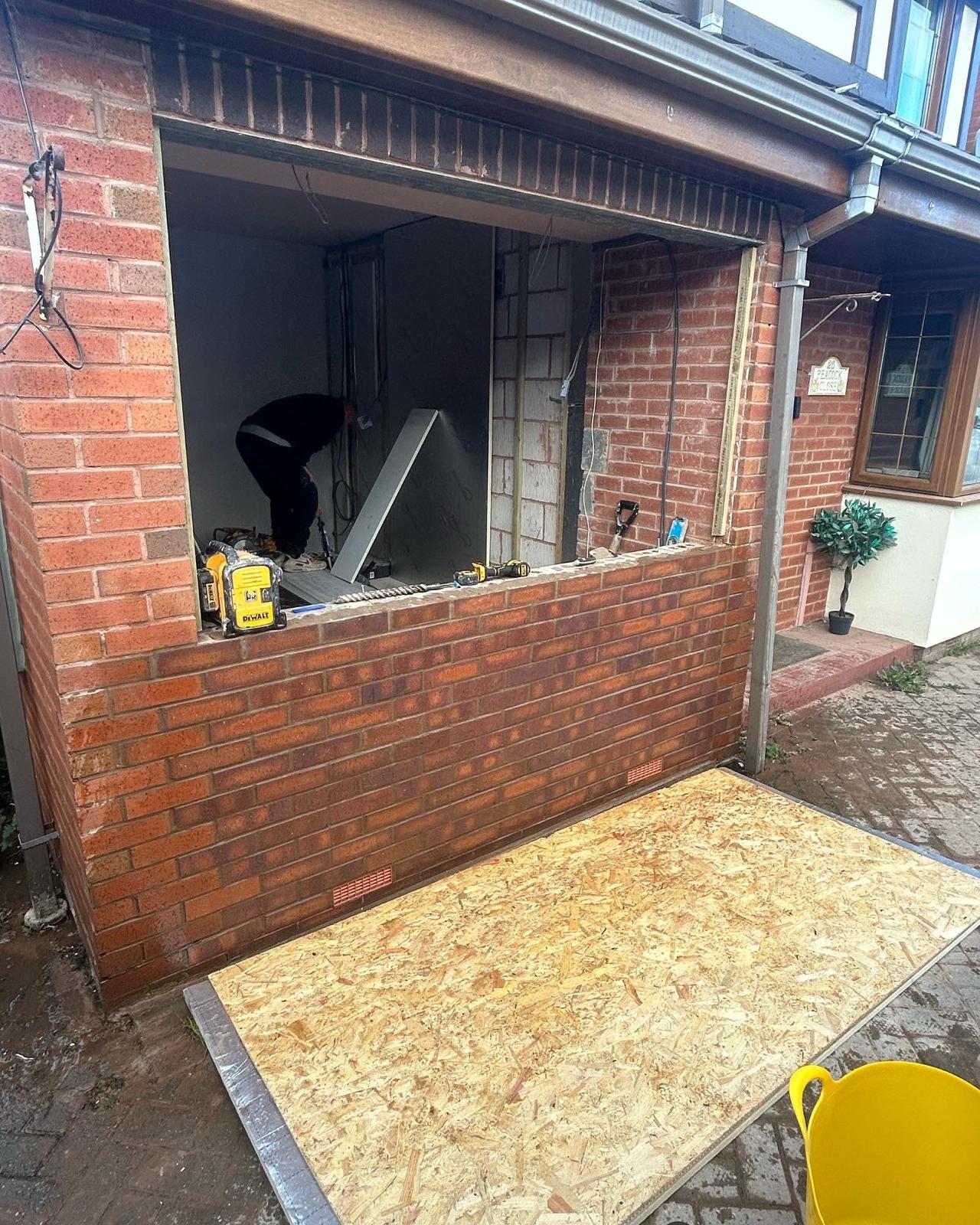 Wide new opening formed in an existing brick wall for an extension
